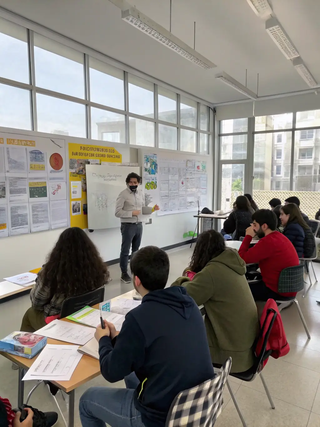 A diverse group of students attentively listening to a lecture in a well-lit classroom, symbolizing the live class component of the Student of Knowledge Program at Bayt al-'Ilm.